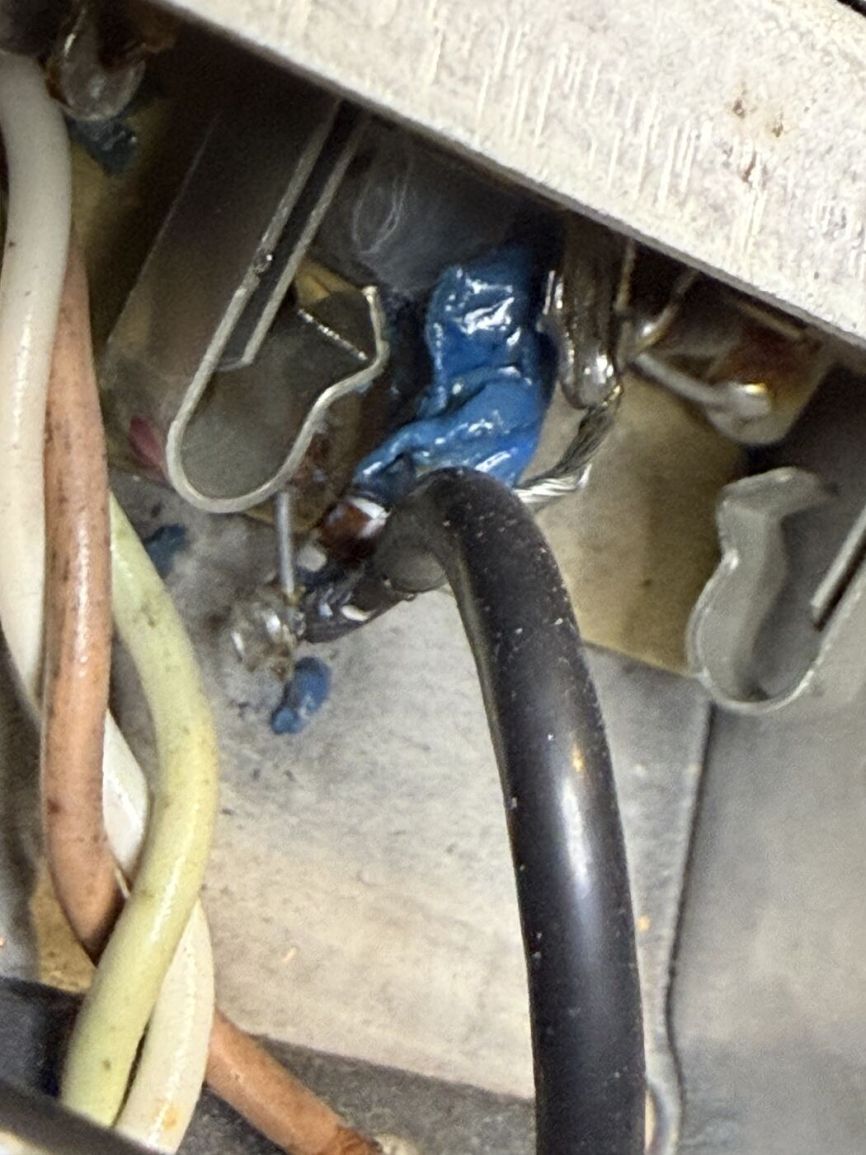 Close-up of a sloppy blue-taped wire splice inside the chassis