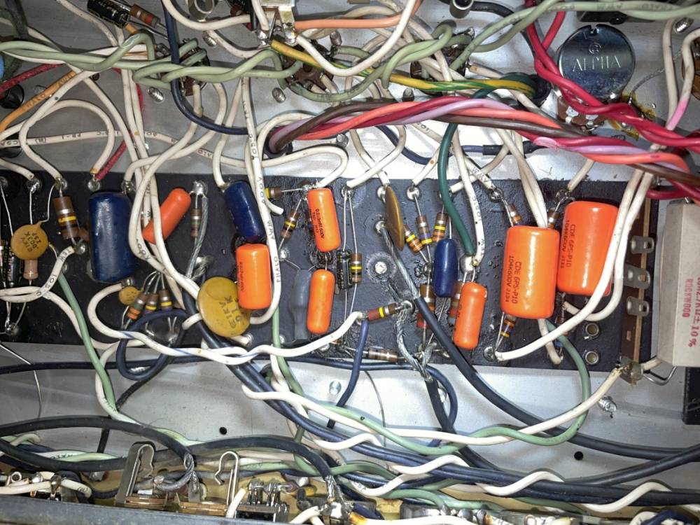 Close-up of new orange drop coupling capacitors replacing leaking originals