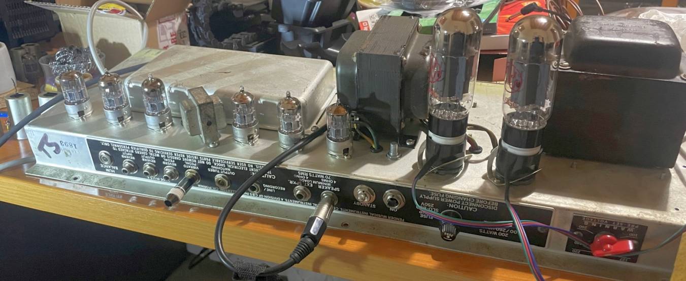 Amp powered up on the bench outside the cabinet, tubes glowing