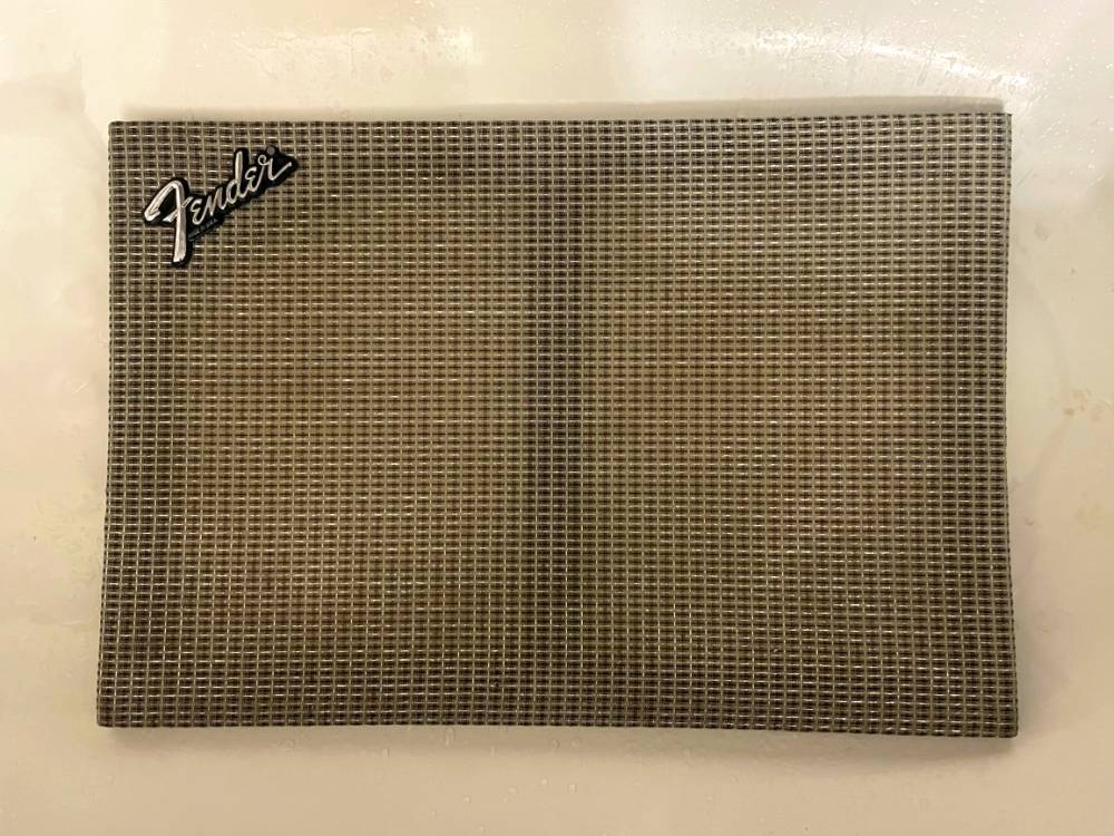 Original grille cloth being cleaned, water visible on the surface